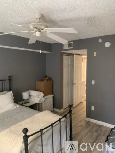 A bedroom with a bed, dresser, and a ceiling fan.