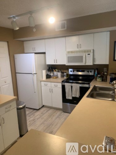 A kitchen with white appliances and cabinets.