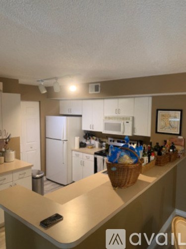 A kitchen with white appliances and a brown counter.