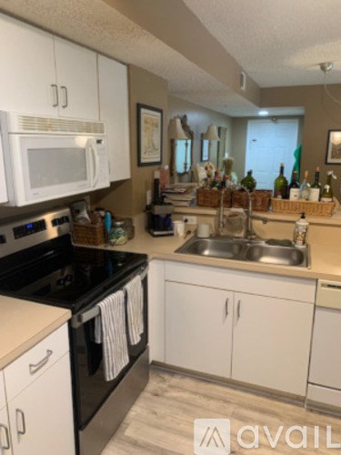 A kitchen with white cabinets and a black stove top.