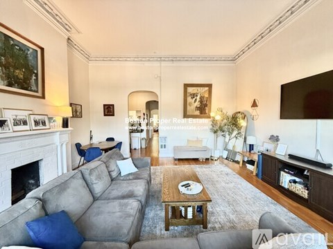 A living room with a grey sofa and a fireplace.