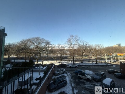 A parking lot with cars and snow on the ground.