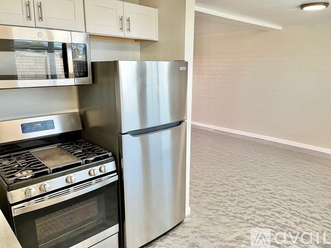 A kitchen with a stove, microwave, and refrigerator.