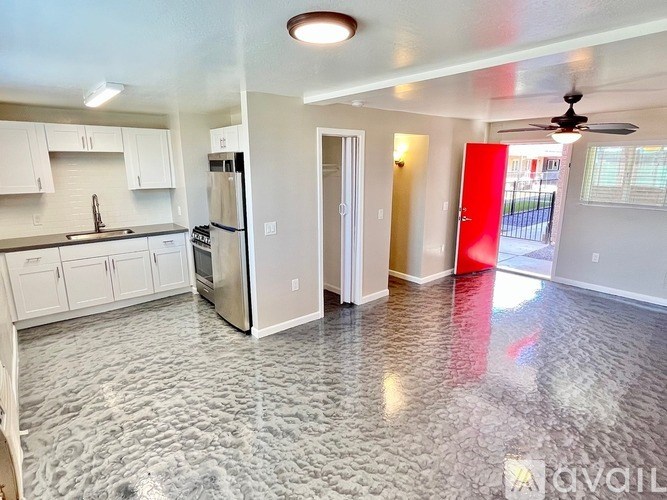 A kitchen with a refrigerator, oven, and sink.