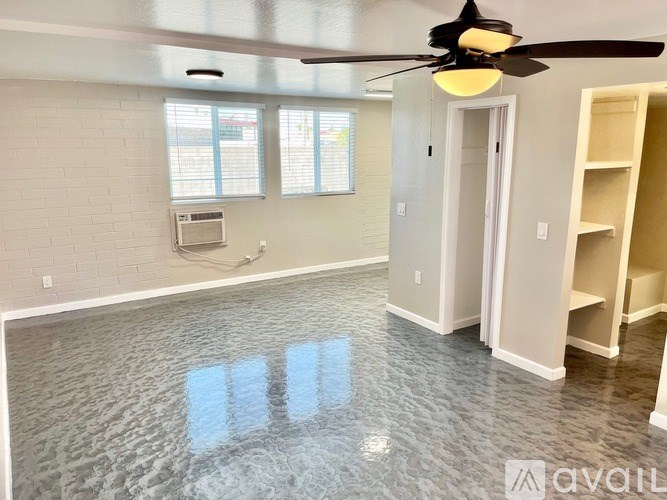 A room with a ceiling fan and a window with blinds.
