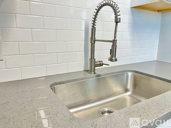 A stainless steel kitchen sink with a chrome faucet.