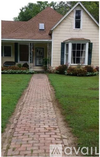 A house with a brick pathway leading to the front door.