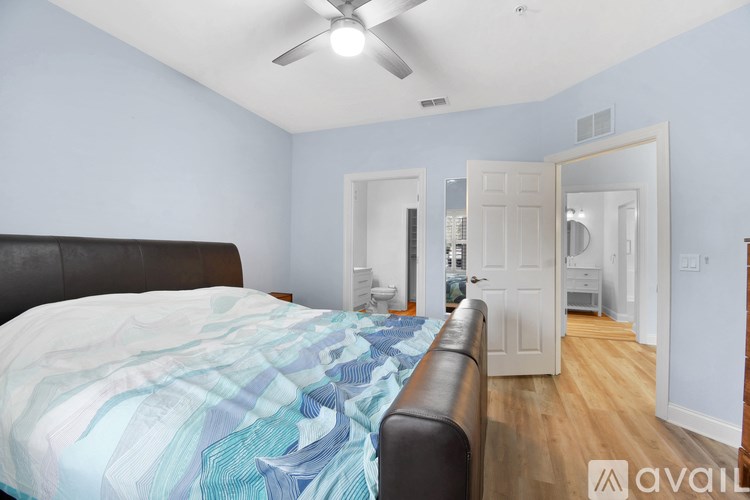 A bedroom with a bed, a couch, and a ceiling fan.