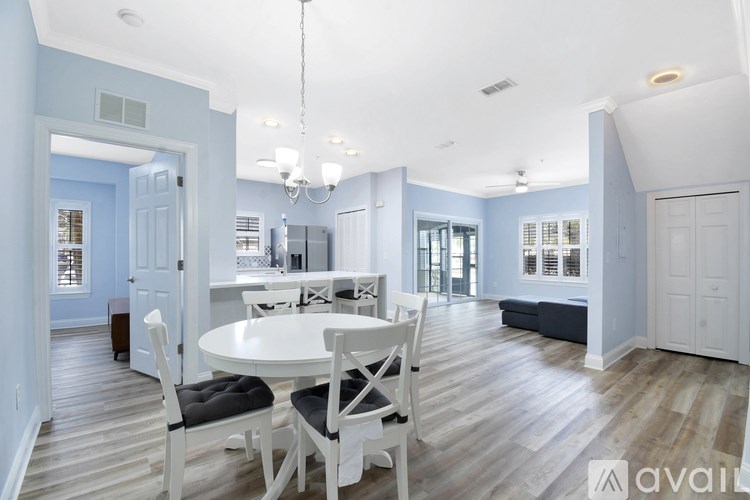 A dining room with a white table and chairs.