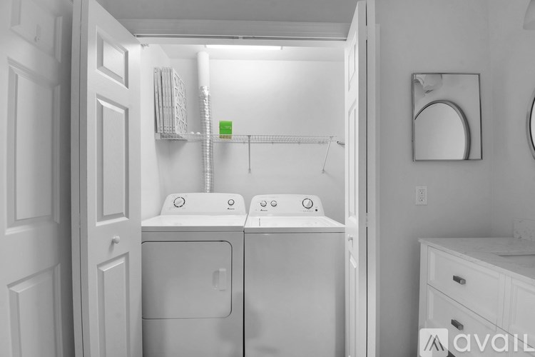 A small white bathroom with a washer and dryer built into the cabinet.