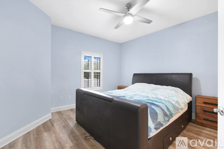 A bedroom with a bed, dresser, and window.