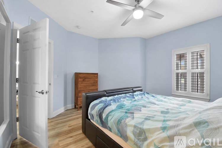 A bedroom with a bed, dresser, and window.