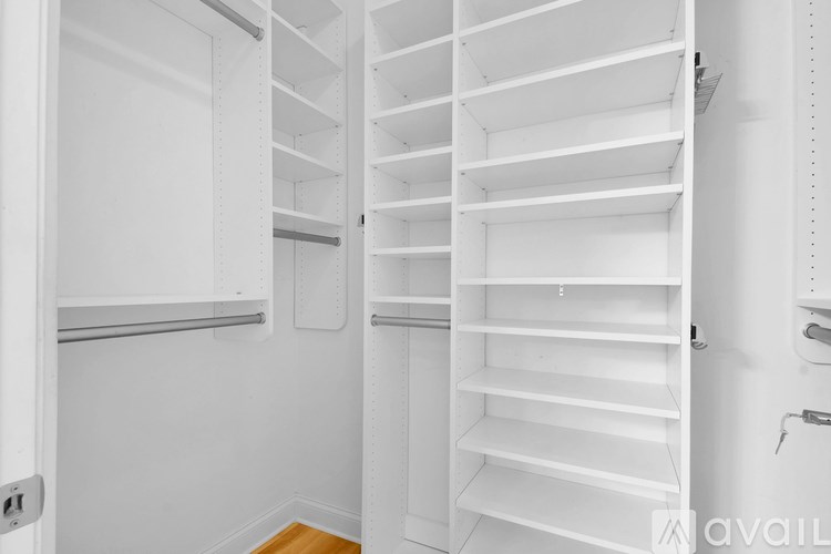A white pantry with shelves and a door open.