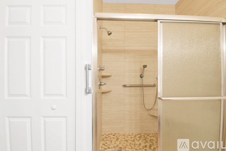 A white door is open to a bathroom with a walk-in shower.