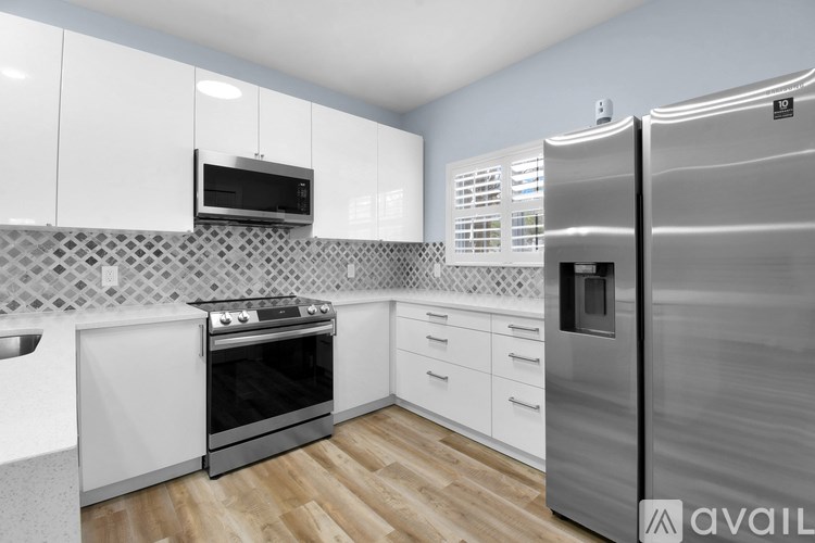A modern kitchen with a stainless steel refrigerator, oven, and microwave.