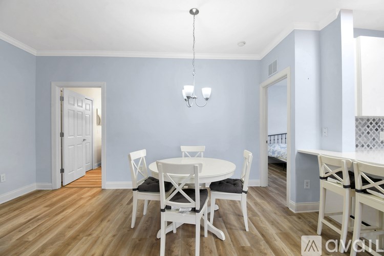 A dining room with a white table and chairs.