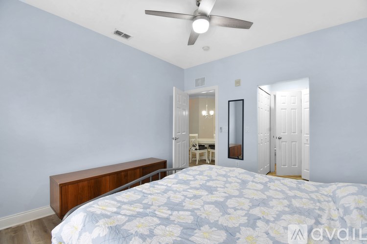 A bedroom with a bed, dresser, and mirror.