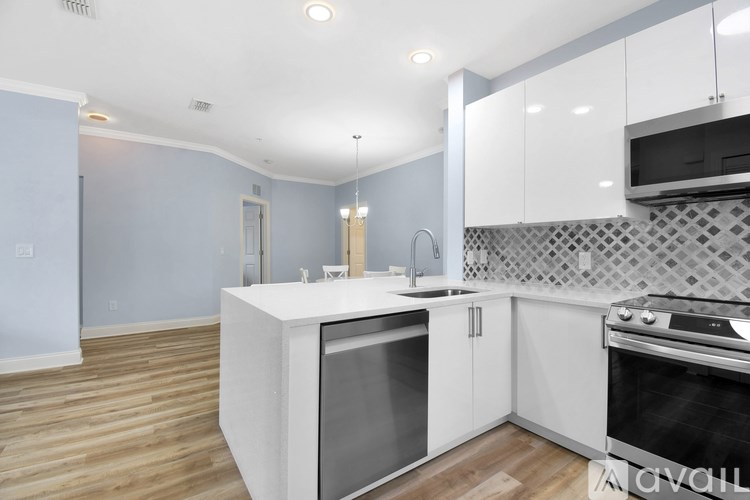 A kitchen with a white countertop and stainless steel appliances.