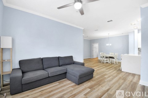 A living room with a grey sofa and wooden flooring.