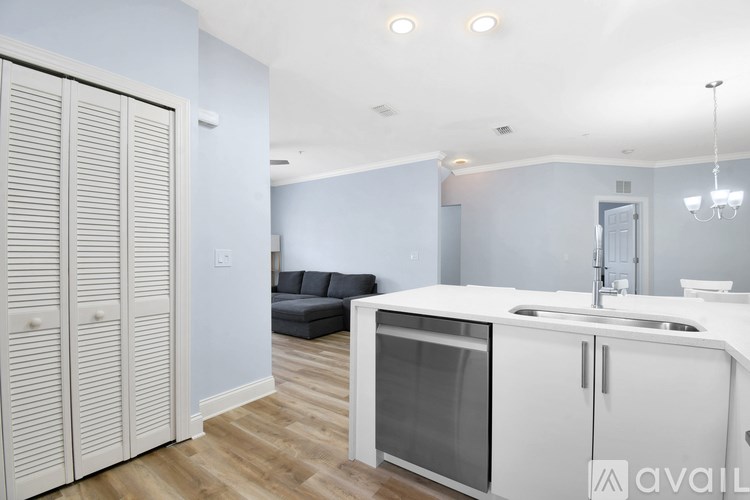 A kitchen with white cabinets and a wooden floor.