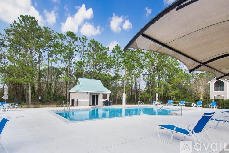 A pool with blue water and chairs around it.