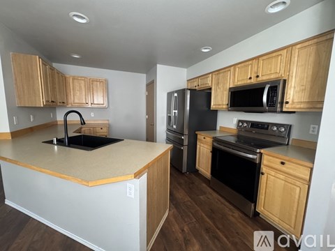 A kitchen with wooden cabinets and black appliances.