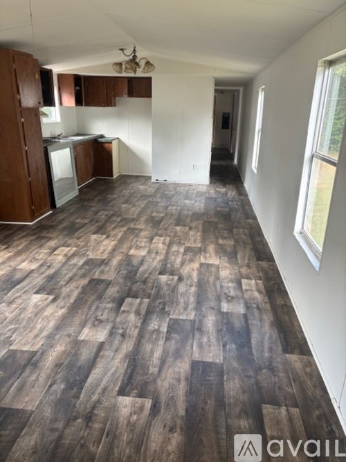 A room with wooden flooring and white walls.