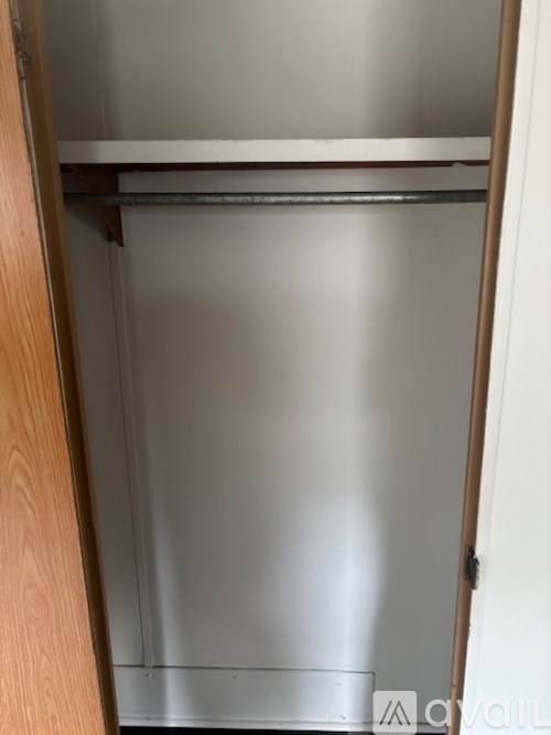 A small, empty closet with a wooden door frame.
