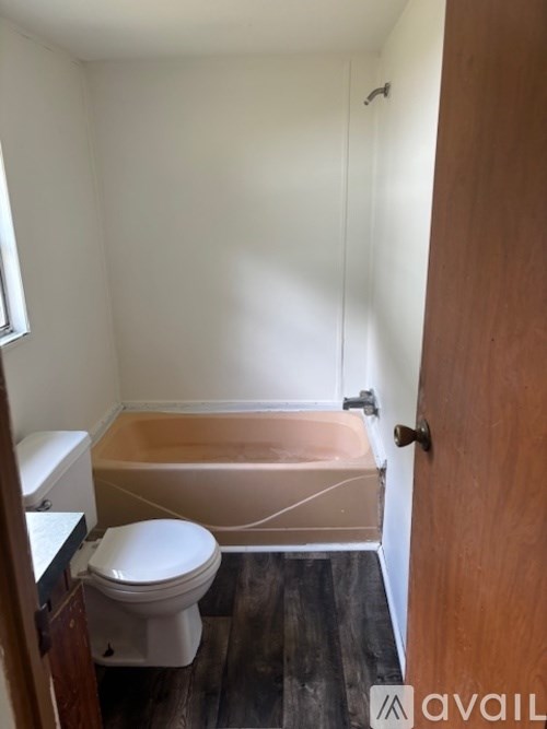 A bathroom with a toilet, sink and bathtub.