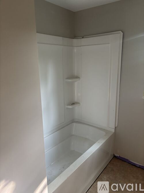 A white bathtub with a shower door in a bathroom.