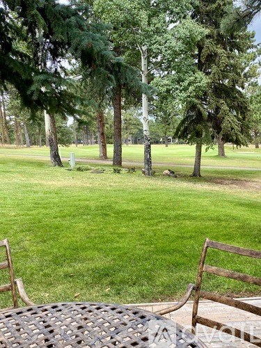 A park with a bench and a table in the foreground.
