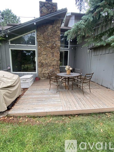 A patio with a table and chairs and a stone pillar.