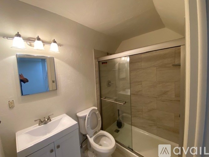 A bathroom with a toilet, sink, and shower.