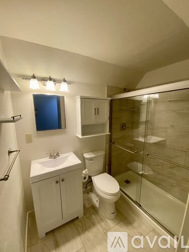 A room with wooden flooring and white walls.