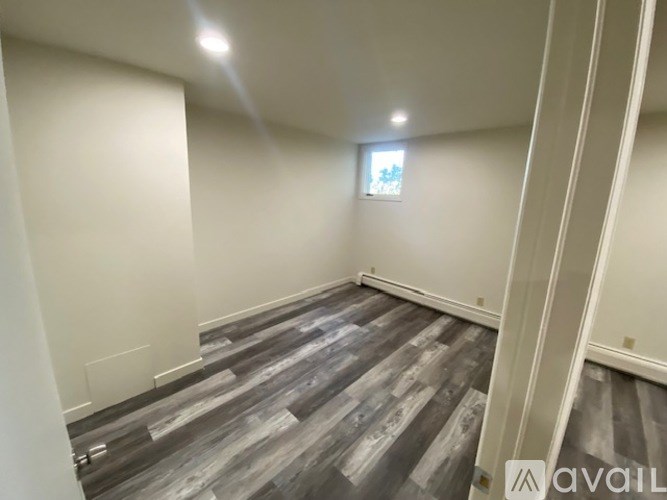 A room with wooden flooring and white walls.