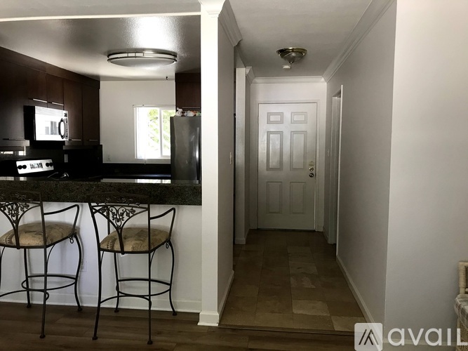 A kitchen with a bar stool and a door.