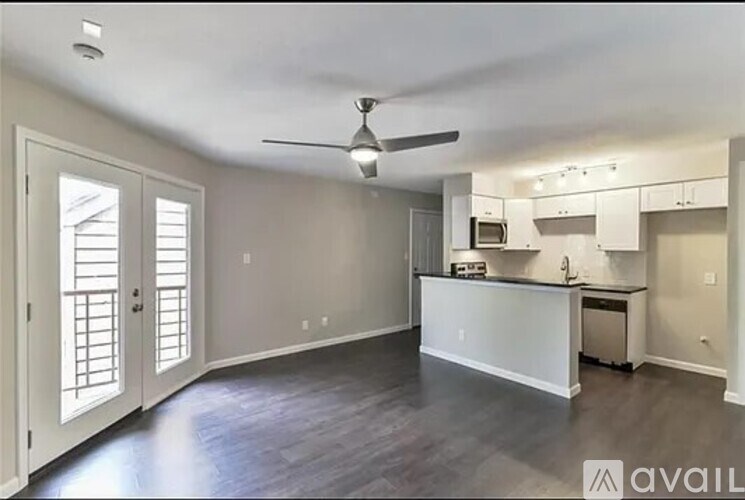 A spacious kitchen and living room with a ceiling fan and sliding doors.
