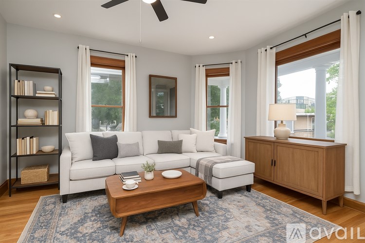 A living room with a white couch, a wooden coffee table, and a ceiling fan.