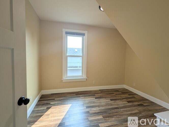 A room with wooden flooring and a window.