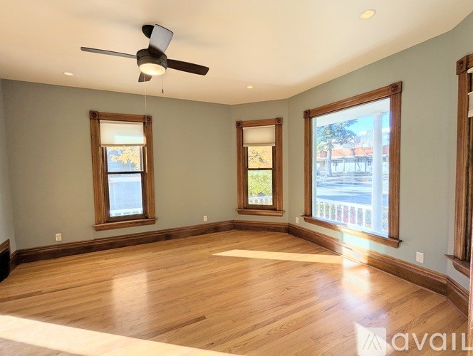 A room with wooden floors and a ceiling fan.