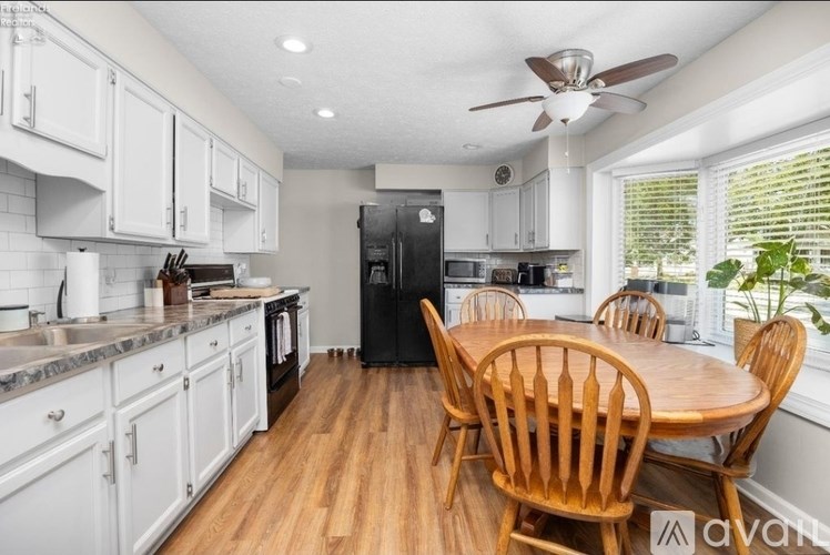A kitchen with a table and chairs in front of a window.