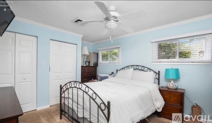 A bedroom with a bed, dresser, and window.