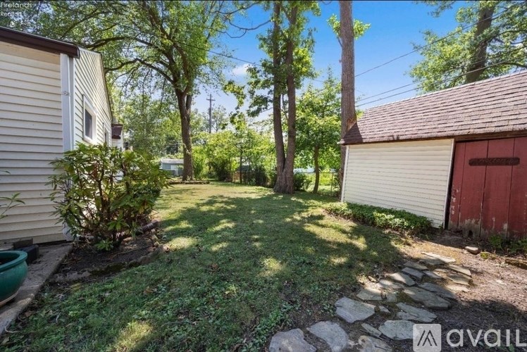 A backyard with a red door and a stone pathway.
