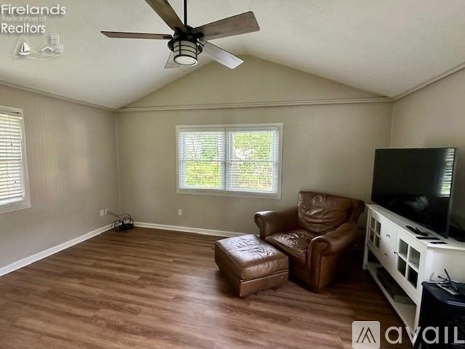 A living room with a brown leather chair and ottoman.