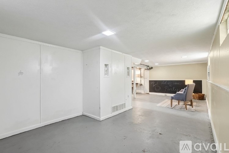 A spacious room with white walls and a grey floor.