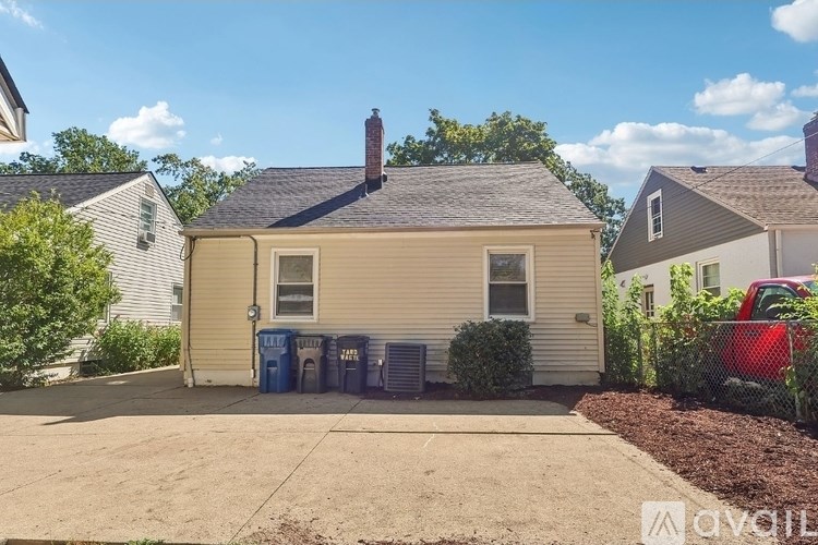 A house with a grey roof and a red car parked in front.