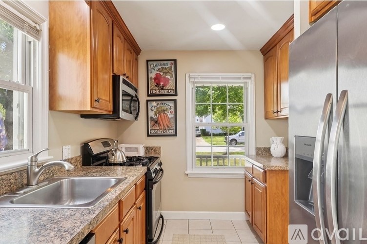 A kitchen with wooden cabinets and a stainless steel refrigerator.