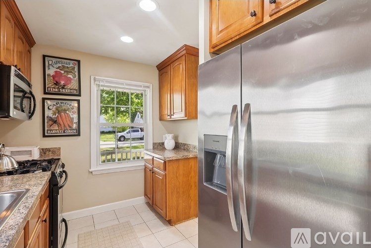 A kitchen with a stainless steel refrigerator and wooden cabinets.