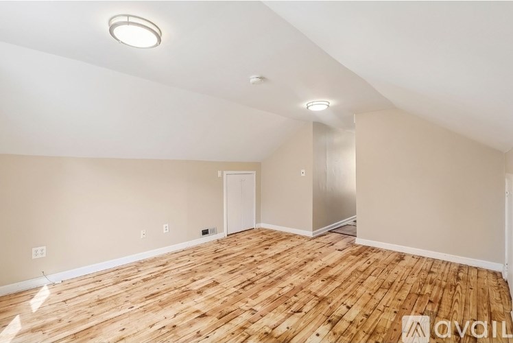 A room with wooden flooring and a white ceiling with a light fixture.