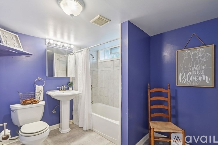 A bathroom with purple walls and a white toilet.